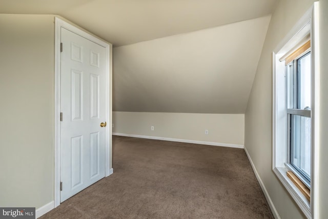 additional living space with vaulted ceiling, carpet floors, and baseboards