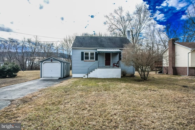 bungalow-style home with driveway, a detached garage, a front lawn, and an outdoor structure