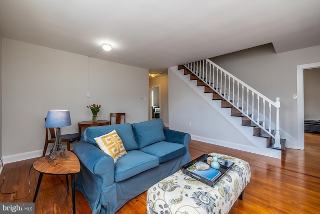 living area featuring stairway, wood finished floors, and baseboards