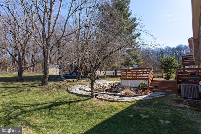 view of yard featuring a deck and central AC unit