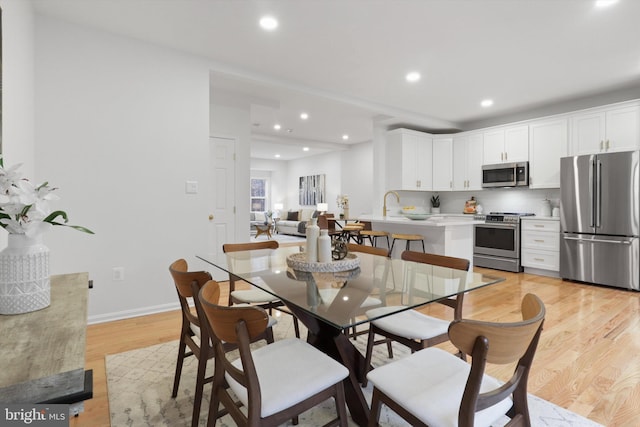 dining room with light wood-style flooring, recessed lighting, and baseboards