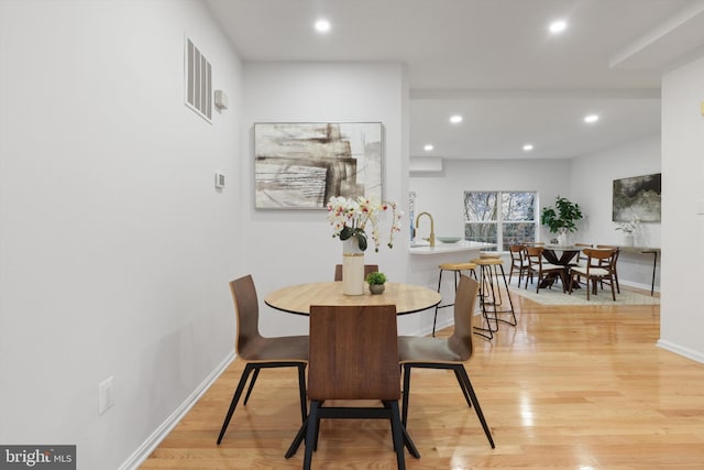 dining room with light wood-style flooring, recessed lighting, and baseboards