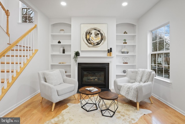 sitting room with built in features, plenty of natural light, and baseboards