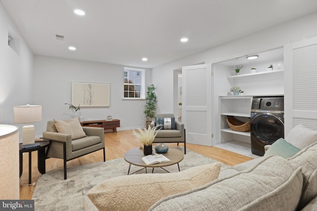 living area featuring recessed lighting, visible vents, washer / dryer, and light wood-style floors