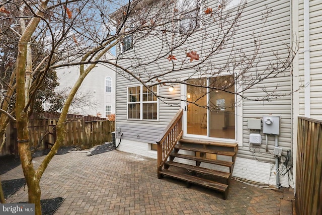 rear view of house with entry steps, a patio area, and fence