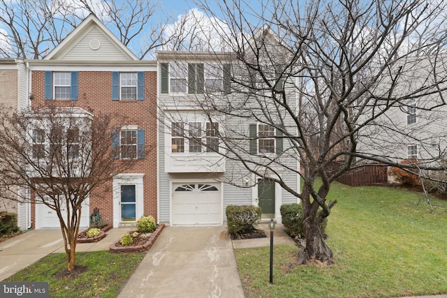 view of property featuring brick siding, driveway, an attached garage, and a front yard