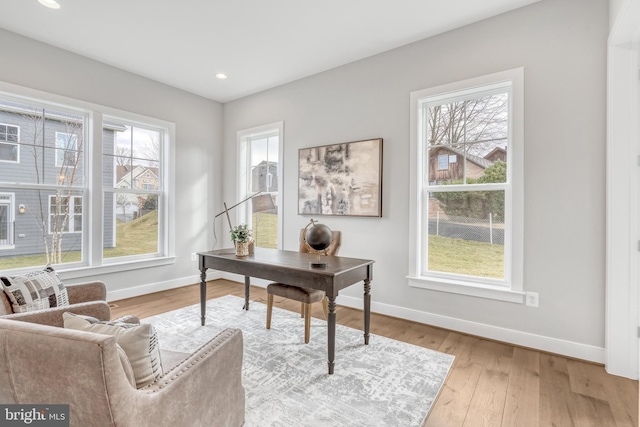 home office featuring baseboards, recessed lighting, light wood-type flooring, and a healthy amount of sunlight