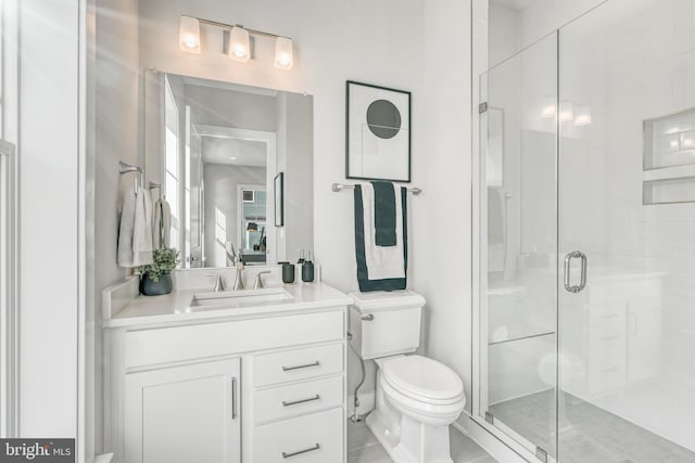 bathroom featuring toilet, a stall shower, and vanity