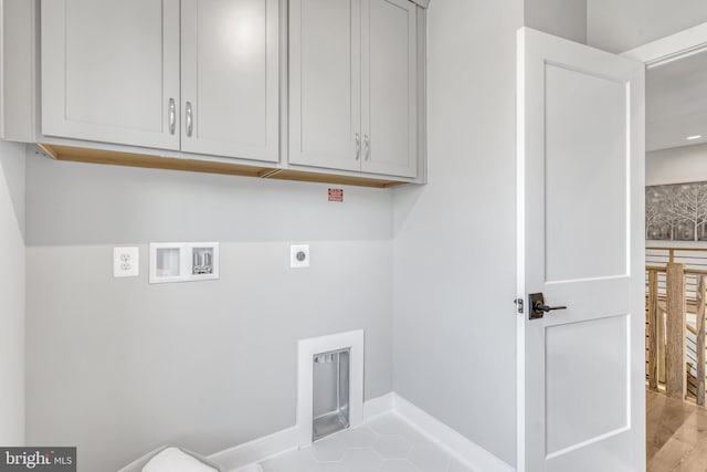 laundry area with cabinet space, baseboards, washer hookup, and electric dryer hookup