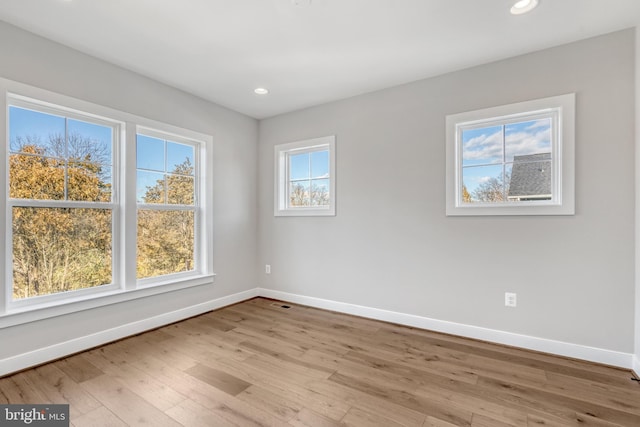 empty room featuring recessed lighting, wood finished floors, and baseboards