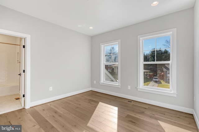 spare room with visible vents, recessed lighting, hardwood / wood-style flooring, and baseboards