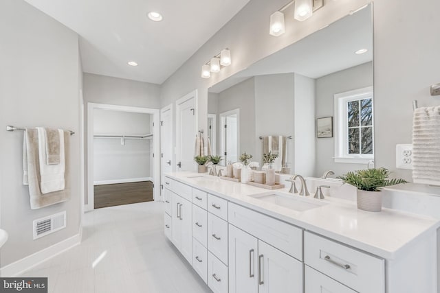 full bathroom with visible vents, a sink, baseboards, and double vanity