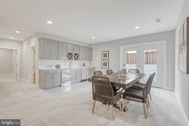 dining room featuring wine cooler, recessed lighting, light colored carpet, visible vents, and indoor wet bar