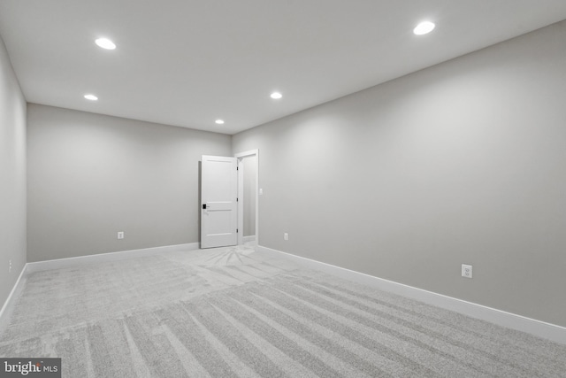 spare room with light carpet, baseboards, and recessed lighting