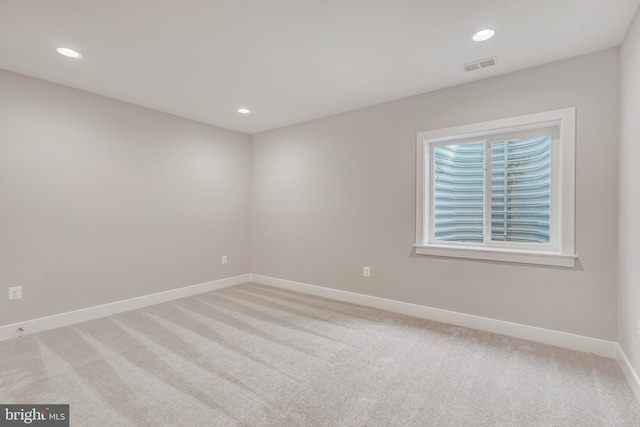 empty room with light colored carpet, visible vents, baseboards, and recessed lighting