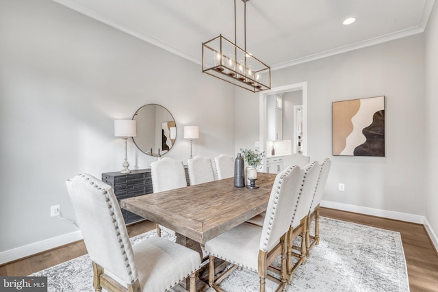 dining area featuring baseboards, wood finished floors, and crown molding