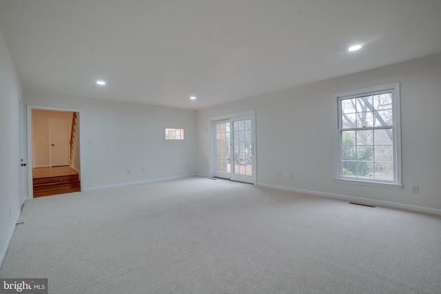 spare room with light colored carpet, recessed lighting, visible vents, and baseboards