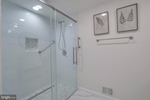 bathroom featuring marble finish floor, baseboards, visible vents, and a stall shower