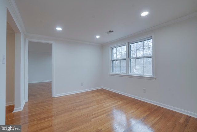 spare room featuring light wood-type flooring, visible vents, ornamental molding, and recessed lighting