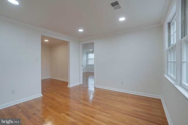 empty room with recessed lighting, visible vents, baseboards, light wood-style floors, and ornamental molding