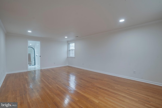 spare room with baseboards, recessed lighting, light wood-style flooring, and crown molding