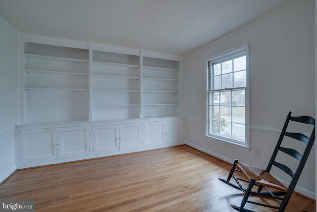 unfurnished room featuring built in features and light wood-style flooring