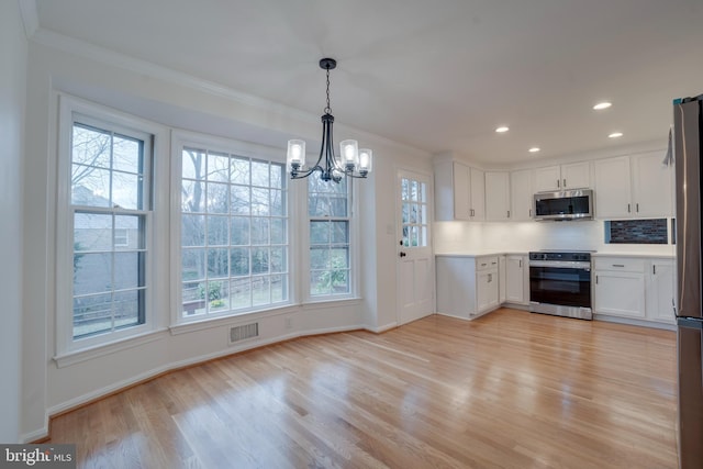 kitchen featuring white cabinets, light wood-style floors, visible vents, and stainless steel appliances