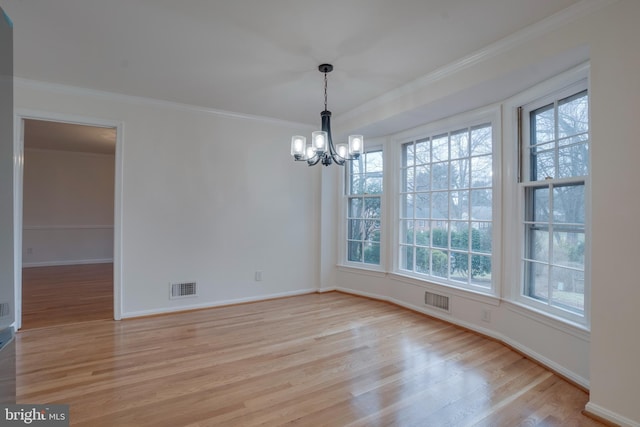 unfurnished dining area featuring ornamental molding, light wood finished floors, visible vents, and a notable chandelier