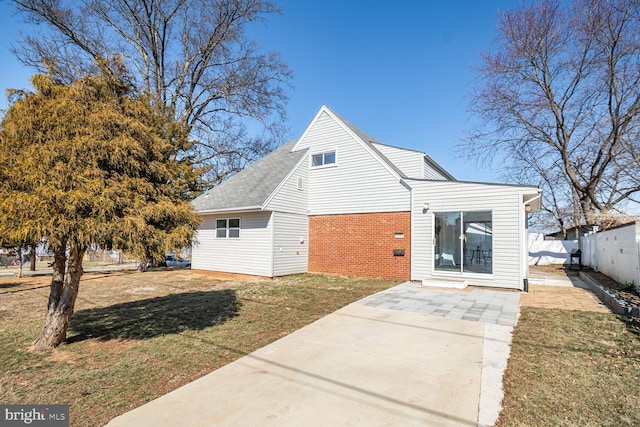 exterior space with a yard, fence, and brick siding