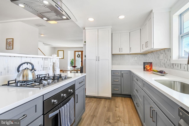 kitchen with wall oven, a wealth of natural light, gray cabinets, and stainless steel gas stovetop