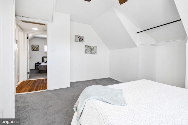 carpeted bedroom with vaulted ceiling, visible vents, and a ceiling fan