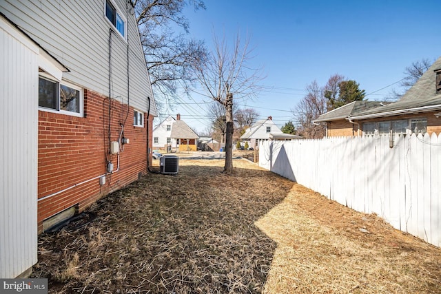 view of yard with central AC unit and fence