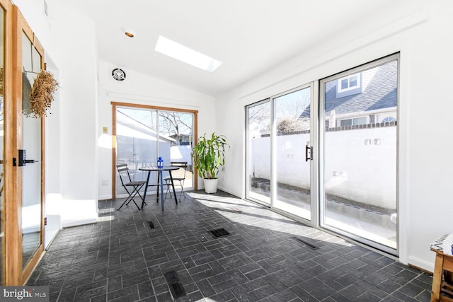 unfurnished sunroom featuring lofted ceiling with skylight