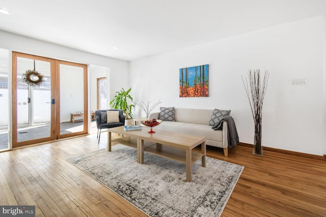 living area featuring french doors, wood-type flooring, and baseboards