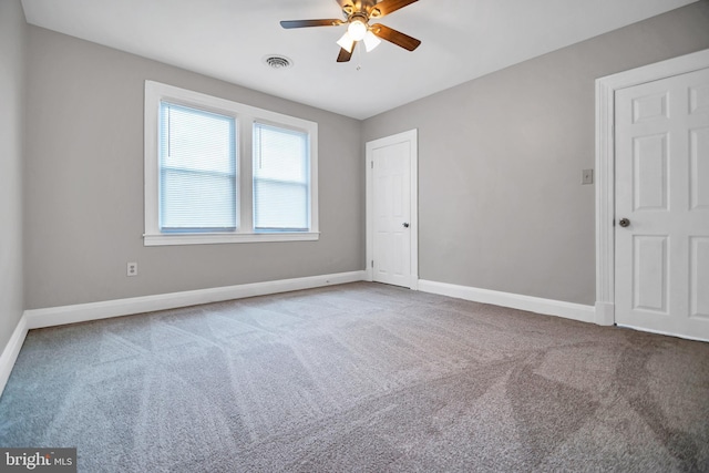 unfurnished room featuring carpet floors, visible vents, ceiling fan, and baseboards