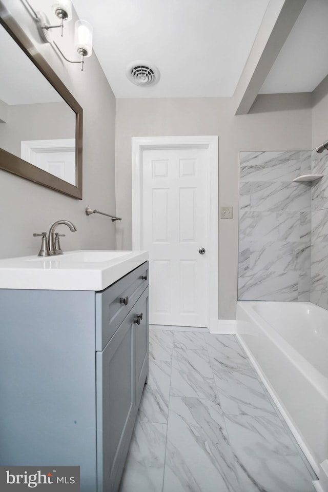 full bath featuring marble finish floor, visible vents, vanity, shower / tub combination, and baseboards