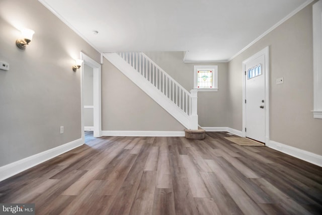 entrance foyer featuring stairs, baseboards, wood finished floors, and ornamental molding