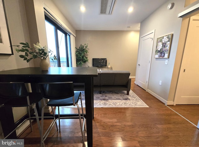 office space featuring recessed lighting, dark wood-style flooring, visible vents, and baseboards