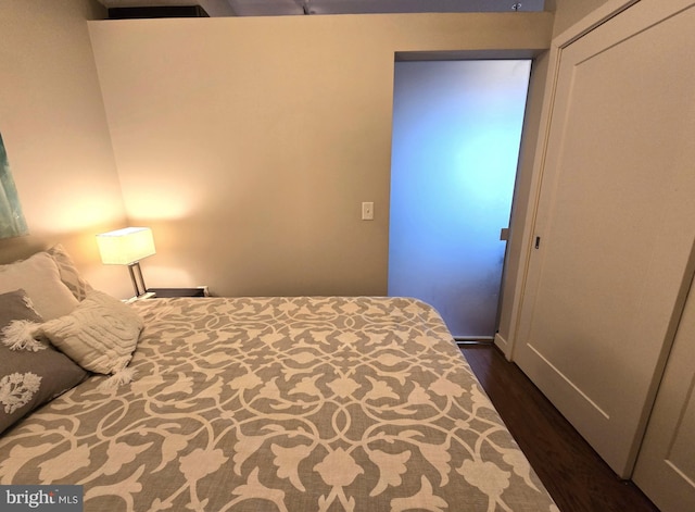 bedroom with a closet and dark wood finished floors