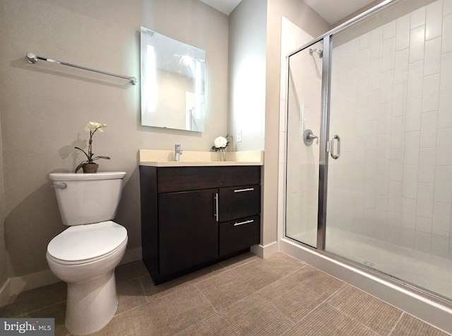 bathroom featuring vanity, a stall shower, tile patterned flooring, and toilet