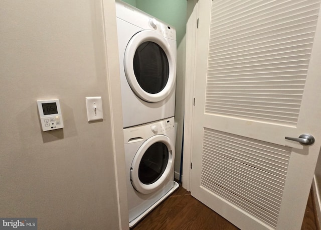 laundry area with stacked washer and dryer, dark wood-style flooring, and laundry area