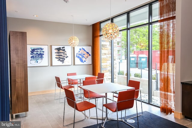 dining area with baseboards, floor to ceiling windows, and a notable chandelier