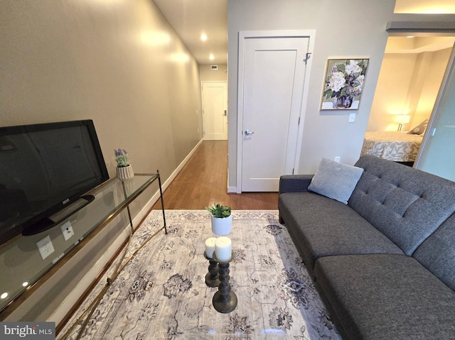 living area with baseboards and wood finished floors