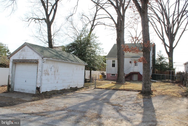 detached garage with driveway and fence