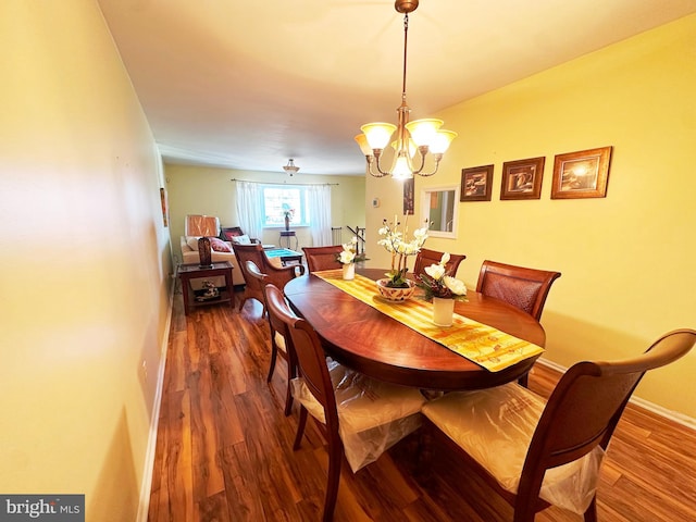 dining area featuring an inviting chandelier, baseboards, and wood finished floors