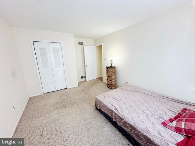 carpeted bedroom featuring a closet, visible vents, and baseboards