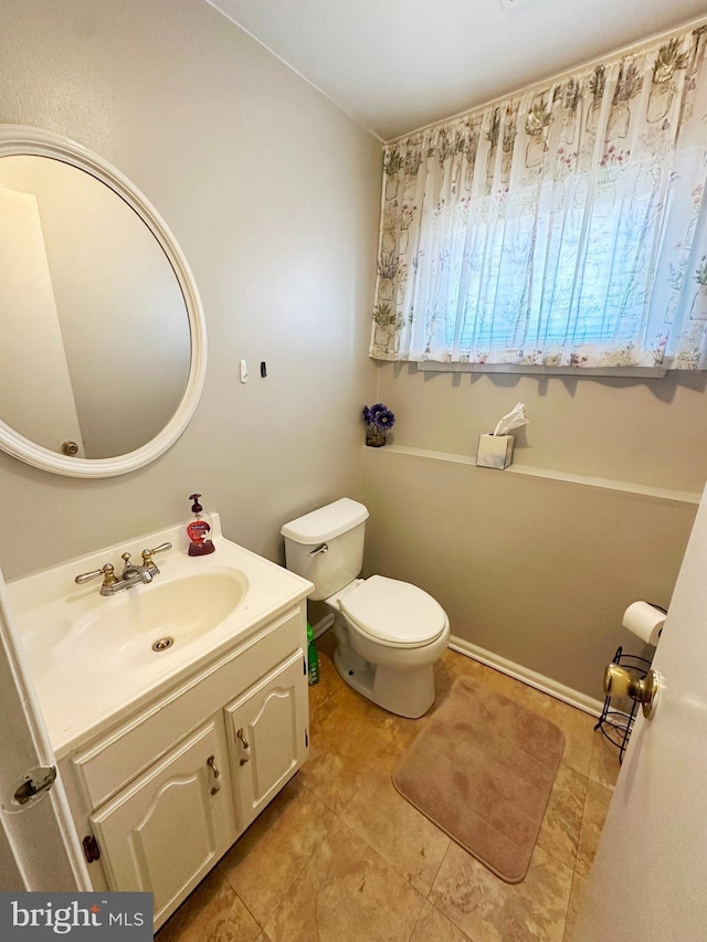 half bathroom with vanity and toilet