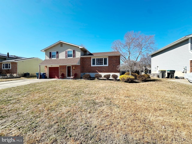 split level home featuring driveway, an attached garage, a front yard, and brick siding