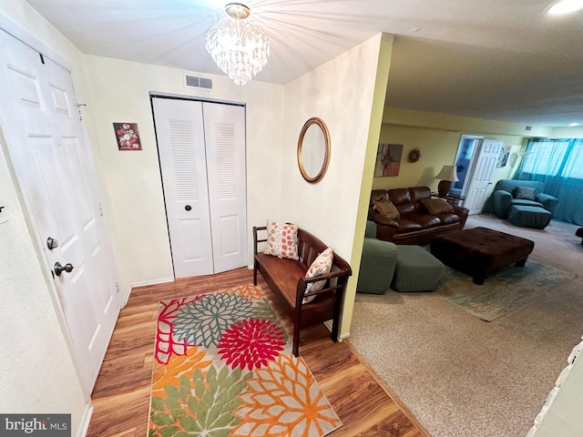 foyer entrance featuring visible vents, a notable chandelier, and wood finished floors