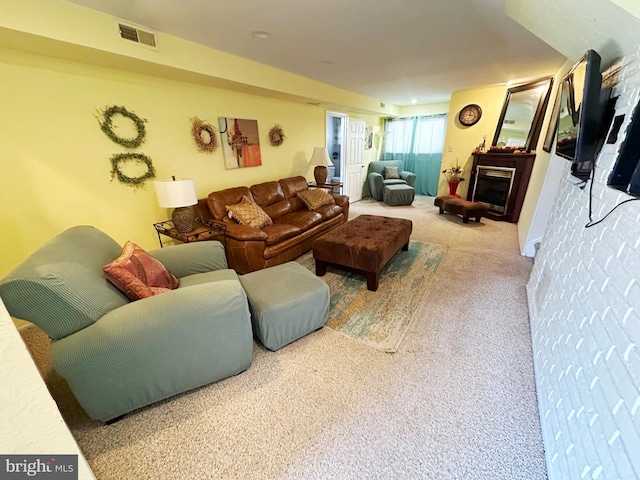 living room featuring a fireplace, visible vents, and carpet flooring